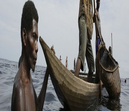 Fischer hält ein Boot fest während Netz aus Bambusstäben ausgelegt wird