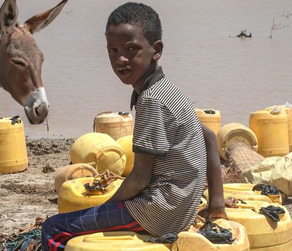An entire pastoralist community, thousands in this region, whose lives are threatened by an unforgiving changing climate, scramble for the little water remaining with their herds, about 100 kilometres from the town of Wajir, in the drought-affected northeastern Kenya, on June 8, 2022. "In twenty days," Hassan, an elder of the community, explains, "there will be nothing left to drink. Then our fate will be in God's hands."